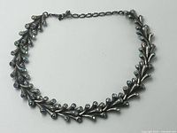 Full view of choker laid flat showing overall design and adjustable chain