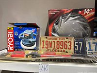 All items on shelf: buffer box, wheel cover box, license plates, The Club
