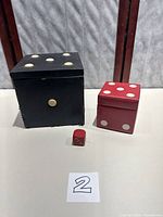Large black dice-shaped box, red dice-shaped box, small red die