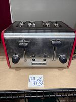 Front view of stainless steel KitchenAid 4-slice toaster showing slots, levers and controls