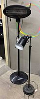 Patio heater and floor lamp standing side by side showing overall form