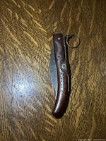 Knife closed showing carved wood handle and metal inlay