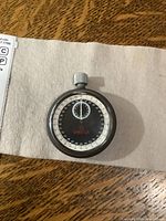 Front view of Omega stopwatch on cloth, showing dial and case