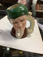 Front view of Royal Doulton Leprechaun pitcher showing facial detail and handle