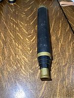 Telescope collapsed showing brass eyepiece and black body