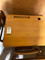 Top view of wooden child’s desk showing ink well hole and pencil groove