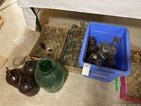 overall lot with cartons of bottles, green demijohn, brown jugs, blue tote