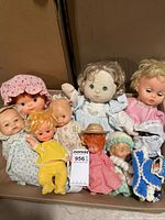 Group shot of all eight dolls laid in box