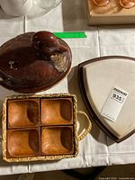 Overview of ceramic hen dish, marble-wood cutting board, wicker tray with four wooden bowls