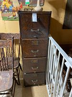 Full view of 4-drawer oak filing cabinet surrounded by other furniture