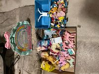 My Little Pony figures in cardboard box, playset case and blue box of small figurines