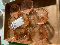 Top view of eight pink depression glass dessert bowls in box