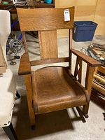 Front view of wood rocking chair showing slat back and saddle seat