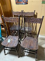 Front view of four pressed back chairs together