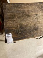 Top view showing worn wooden surface and lot tag