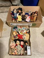 Two trays of assorted dolls, top view