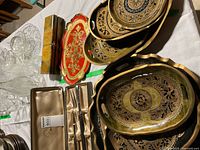 Stack of eight decorative Mexican trays with scalloped gold edges