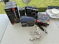 Boxed NOMA rope light, four boxed NOMA LED strip lights, boxed NOMA laser projector, loose power cord and stake