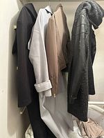 Four coats and jackets hanging on rail