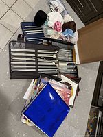 Overall view of knitting needles, yarn, pattern stack