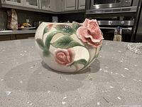 Front view showing floral relief motif on porcelain candle holder