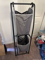 Full view of hamper front showing two grey bags in black frame