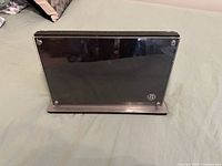 Front view of stainless and acrylic magnetic knife block showing reflective panel and emblem