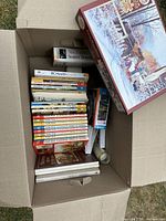 Overview of box contents showing books, jigsaw puzzle and rolled item