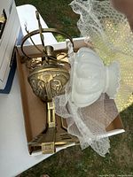Boxed brass hanging light fixture and separate milk glass shade wrapped in bubble wrap