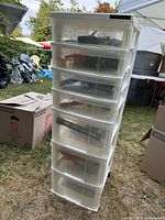 Full view of plastic drawer tower showing seven clear drawers filled with hardware