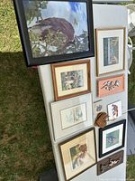 Overall view showing framed prints, plaques, glove on table