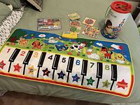 Overall lot showing piano mat, block tub, puzzles and small toy