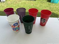 Six assorted Starbucks reusable plastic cups displayed on table