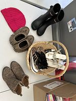 All six pairs of shoes and pink knit hat displayed on table