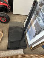 Full view of TV stand showing glass base, shelf, and vertical support column