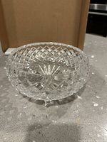 Side view of clear cut crystal bowl showing diamond pattern and three feet