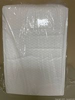 Front view of bundled white bubble mailers in plastic wrap