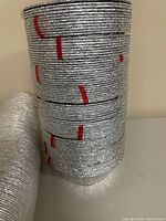 Unwrapped sleeve of stacked silver baking cups with red bands