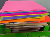 Stack of multi-colour craft paper sheets on box