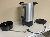 Percolator urn with lid, basket, stem and power cord displayed