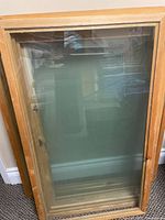 Stack of wood-framed windows leaning against wall