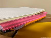 Loose stack of lined and pink colored sheets