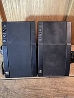 Front view of both Acoustic Research Powered Partner 570 speakers showing control buttons and grilles