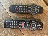 Top view of both Rogers remote controls showing button layout and branding