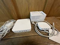 AirPort Extreme, AirPort Express, box and cables on wooden surface