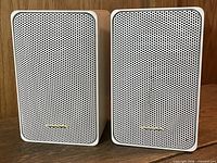 Front view of both white Realistic Minimus 7 speakers with perforated metal grilles