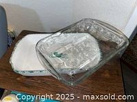 Two baking dishes: clear glass floral-embossed and white ceramic with green rim