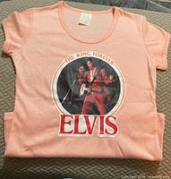 Front view of folded pink Elvis graphic T-shirt