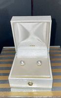 Pearl stud earrings displayed in open presentation box