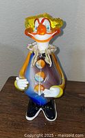 Full front view of Murano glass clown showing multicolour body, buttons, hands and shoes